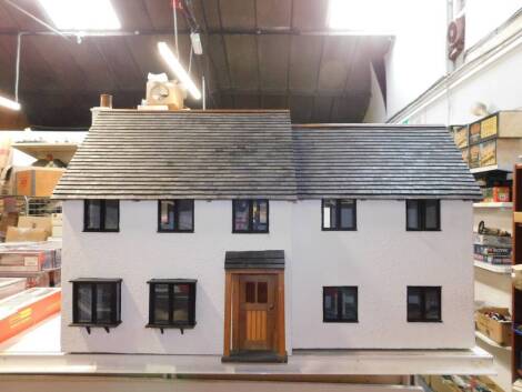 A wooden model of a dolls house, two storey, rendered in white, with two doors, opening to reveal various rooms, 56cm H, 91cm W, 40cm D.