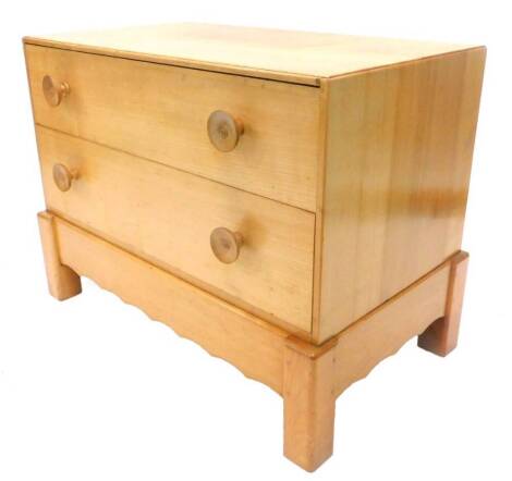 An Arts and Crafts fruitwood small chest of drawers, the caddy top above two drawers, each with turned wooden handles on block feet, with shaped apron, 63cm H, 50cm D, 85cm W.