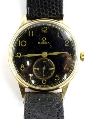 An Omega gents wristwatch, with blackened dial and seconds dial, with gold hands, in a yellow metal case, marked to the inside, with a modern black leather strap, movement numbered 6985432, mark rubbed, the dial 3.2cm W, 41.5g all in.