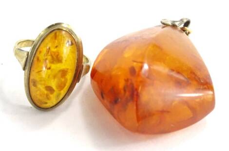 Two items of imitation amber jewellery, comprising a oval set dress ring, on a yellow metal band, stamped 333, ring size J, together with a pendant with silver clasp, the pendant 4cm H. (2)