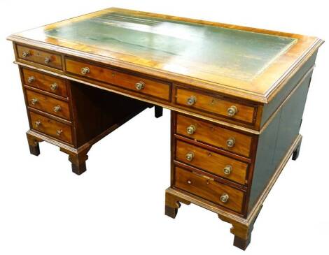 A mahogany desk in George III style, the rectangular top with a green leather inset above an arrangement of nine crossbanded drawers on bracket feet, raised in height, (AF), 61cm H, 152cm W.