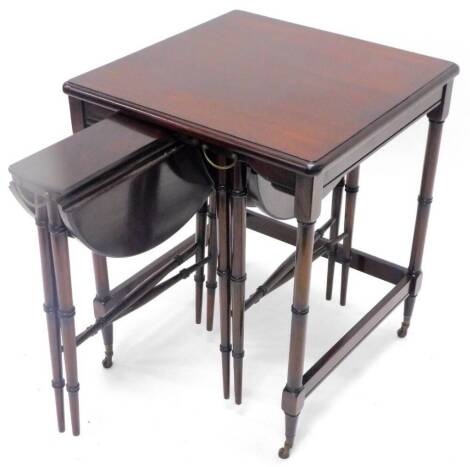 A mahogany nest of three tables, the largest table with a moulded edge on turned tapering legs, housing two smaller tables, each with an oval drop leaf top on turned tapering legs, 48cm W.