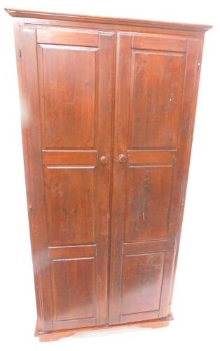 A stained pine wardrobe, with two panel doors, on bracket feet, 89cm W.