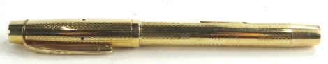 An Onoto gold plated fountain pen, with engine turned decoration.