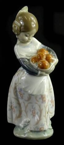 A Lladro figure, of a girl holding basket of oranges, printed marks beneath, 17cm H.