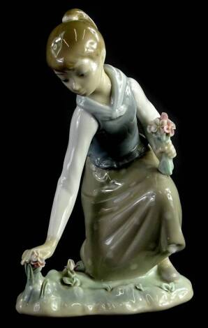 A Lladro figure, of a girl picking flowers on naturalistic base, number I-6A, printed and impressed marks beneath, 20cm H.