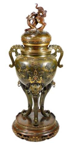 A fine Japanese two-colour patinated bronze koro, with gilt piquet work embellishments, silvered inlays and aplliques of coral and mother-of-pearl, the pierced and domed cover having Kylin surmount, dragon banded insert, the two-handle bulbous body with s