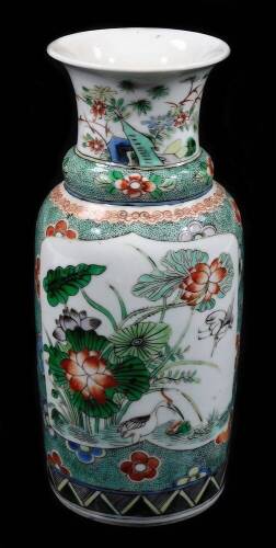 A Chinese porcelain famille vert baluster vase, decorated with panels of hollyhock and watery landscapes, with a stippled ground six character mark, 20cm H.