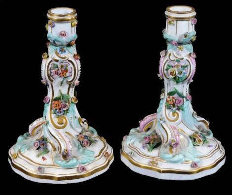 A pair of 19thC Meissen porcelain rococo candlesticks, decorated with applied flowers and scattered insects, blue crossed swords mark, 18cm H.