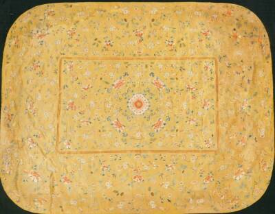 A Imperial Chinese Qing period brocade silk cushion cover, on yellow ground raised with exotic flowers, predominately in orange, blue and green, on material backed ground, 133cm x 103cm.