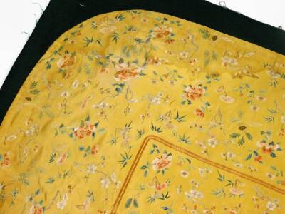 A Imperial Chinese Qing period brocade silk cushion cover, on yellow ground raised with exotic flowers, predominately in orange, blue and green, on material backed ground, 133cm x 103cm. - 4