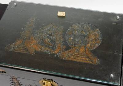 A 20thC Chinese lacquer camphor wood chest, of shaped rectangular form, the glass top revealing a heavily carved panel section of buildings, figures and boats, with a heavily carved front and lock, c1957, with key and receipt of sale, 50cm H, 93cm W, 52cm - 2