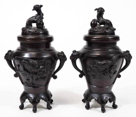 A pair of Japanese Meiji period bronze koro with covers, of small proportion, each pierced lid with animal knops on shaped bodies and feet, flanked by S scroll handles and raised with panels of flowers to each side, unmarked, 17cm H.