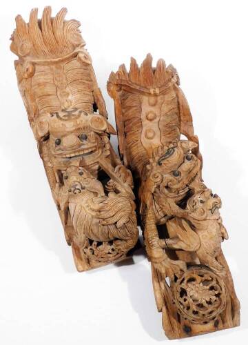 A matched pair of Chinese wooden carvings, of a dragon and young, heavily carved and picked out in black, 70cm H, and another similar. (2)