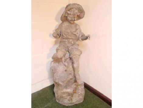 A re-constituted stone garden figure of a seated fisher boy on a rock in