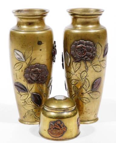 A pair of Japanese bronze baluster vases, late Meiji period, of shouldered form raised with flowerheads raised in a two-colour relief, unmarked, 16cm H, and a similar inkwell set with compass. (3)