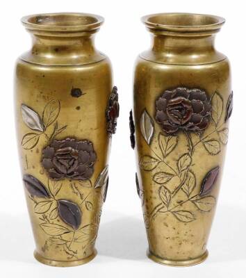 A pair of Japanese bronze baluster vases, late Meiji period, of shouldered form raised with flowerheads raised in a two-colour relief, unmarked, 16cm H, and a similar inkwell set with compass. (3) - 3