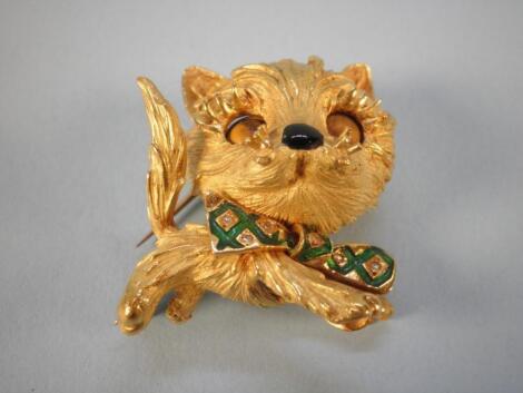 A yellow metal brooch in the form of a kitten with tiger's eye and enamelled bow tie