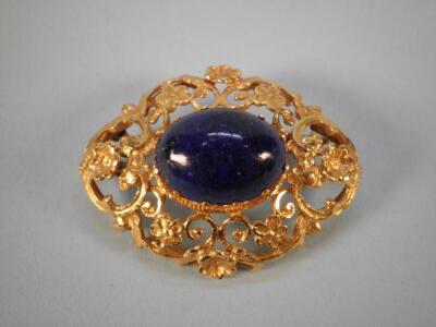 A yellow metal brooch inset with a lapis lazuli