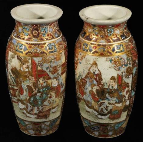 A pair of Meiji period Japanese pottery Satsuma vases, each of shouldered form, profusely decorated with panels of figures in an exterior setting, broken by a geometric pattern predominately in orange, blue and green with gilt highlights, unmarked, 21cm H