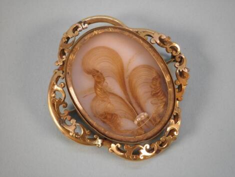 A memorial brooch, the lobed mount decorated with scrolls surrounding