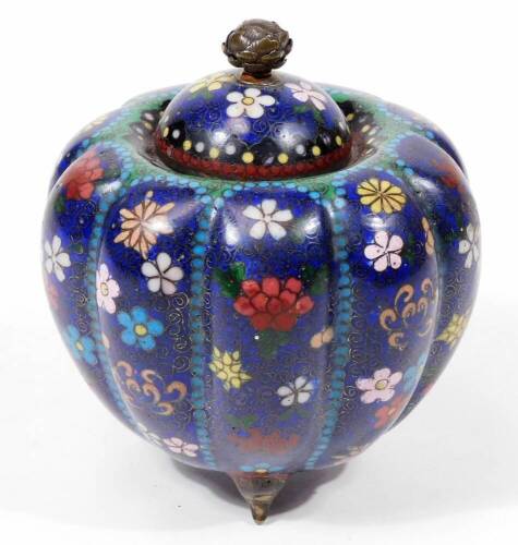 An early 20thC Chinese cloisonné jar and cover, of melon shape, with domed lid, profusely decorated with flowers predominately in red, pink and white on a blue and turquoise ground, on triple shaped feet, 12cm H.