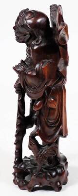 An early 20thC Chinese root carving, of a bearded sage in flowing robes holding staff in a naturalistic setting, 28cm H. - 2