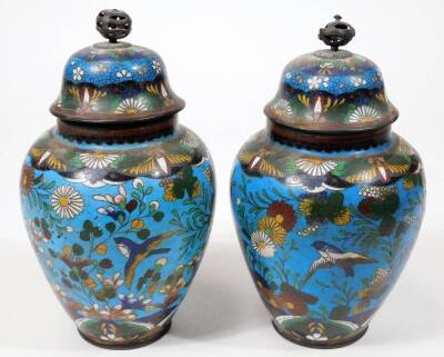 A pair of early 20thC Chinese cloisonné vases, each of shouldered circular form, decorated with flowers predominately in blue, green and white, with a further pair of cloisonné open vases with cylindrical stems and compressed domed bodies. (4) - 6