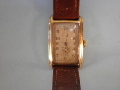 A yellow metal gent's wrist watch in Art Deco style with brown