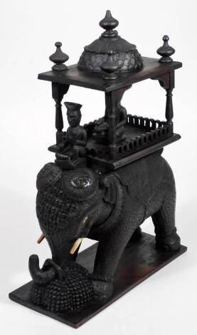 A Burmese carved wooden statue figure group, of an elephant with rider and elaborately carved top, on a rectangular base, unmarked, 48cm H.