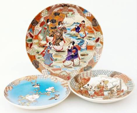 A Japanese late Meiji period Satsuma dish, of circular form, polychrome decorated with geisha, predominately in brown, green and blue, on a circular foot, 33cm Dia., a further Japanese Satsuma plate with decorative base, set with various bearded figures a