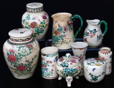 Various Japanese Meiji period pottery vases, etc. comprising a cylindrical example, florally decorated with flowering shrubs, predominately in blue, pink and green, with a red line banding, 9cm H and various similarly decorated pottery pieces, lidded jar