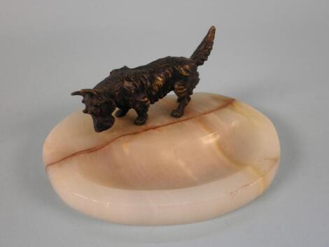 An onyx ashtray mounted with a cold painted bronze figure of a Scottie dog