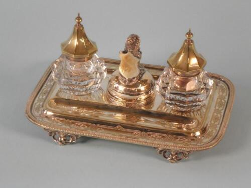 An Edwardian silver plated ink stand with two ink pots and a central lidded