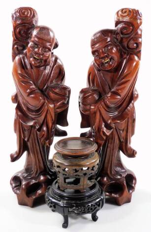 A similar pair of root carvings of sages, each standing on naturalistic settings in flowing robes, on part pierced bases, 44cm H and two carved wooden vase stand. (4)