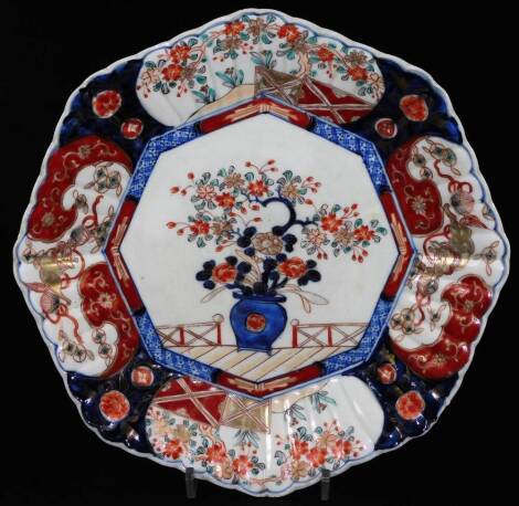 A Japanese Imari plate, of octagonal form, centred with a vase of flowers with a floral border, typically decorated in blue and red with gilt highlights, unmarked, 28cm W.