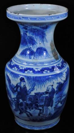 A Chinese Qing period porcelain blue and white vase, with inverted trumpet stem and shouldered body, profusely decorated with figures in an exterior setting, set with trees with an upper floral banding, unmarked, 36cm H. (AF)