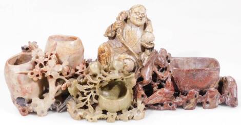 A Chinese carved soapstone figure, of a sage seated in flowing robes holding staff, 10cm H, on a shaped wooden base and three other carved soapstone figure groups, vases with flowers, etc. (4)