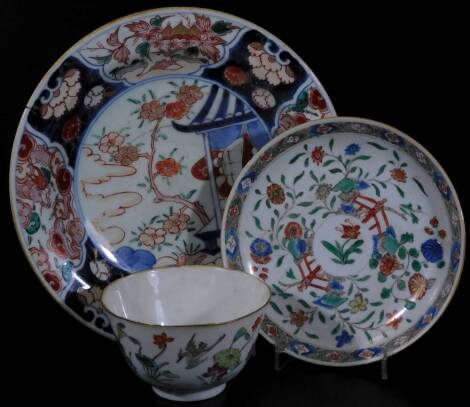 A Chinese Republic porcelain tea bowl, polychrome decorated with exotic bird and flowers, predominately in orange, pink and green, with a seal mark beneath, 10cm Dia., a Kangxi period saucer, polychrome decorated with flowers and fence, in colours with a 