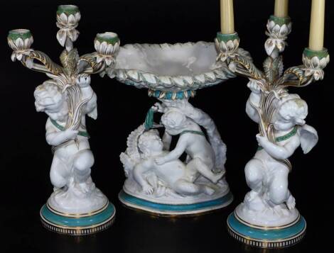 A 19thC Copeland porcelain centrepiece garniture, comprising dish of oval form held by fighting cherubs, on a naturalistic base with turquoise highlights, 31cm H and two candlestick garniture, each formed with cherub stems on circular feet, impressed mark