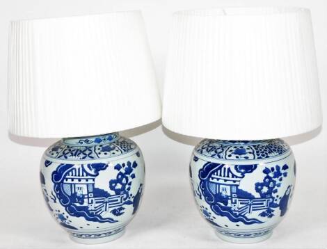 Two Qing style blue and white Chinese porcelain lamp vases, of large proportion, with fixed lids, each body profusely decorated with figures and trees, with shades, late 20thC , 75cm H. (2)