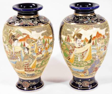 A pair of early 20thC Japanese ovoid vases, each decorated with panels of figures and raised with gilt highlights, predominately in green, red and yellow, on circular feet, marked beneath, 24cm H. (2)