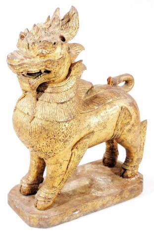 A 19thC gilt wood temple lion, in standing pose on canted base, 47cm H.