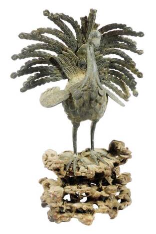 A 19thC bronze figure of a bird, with pierced and elaborate plumage, on a root carved base, 28cm H (AF)