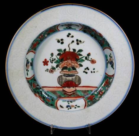 A Chinese famille verte porcelain dish, decorated with centre vase of flowers, with an inner border of flowers panels and green stippled ground and a outer border of bianco sopra bianco flowers, 22cm Dia.