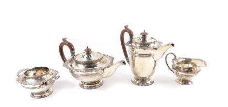 A George V silver four piece tea and coffee service, of baluster form, with fluted banding, shell and scroll gadrooning, and handles with serpent terminals, comprising tea pot, coffee pot, cream jug, and sugar bowl, Walker & Hall, Sheffield 1931, 82.92oz.