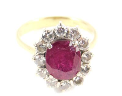 An 18ct ruby and diamond ring, the oval cut ruby, approx 3.5cts, in a surround of twelve diamonds, approx 1.08cts, size N/O, 5.4g. - 2