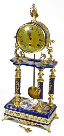 A late 20thC Continental gilt metal and porcelain finish mantel clock, the elaborate case holding a 10cm Dia dial surmounted by a figure finial on turned columns and a platform base terminating in quadruple hairy paw feet in the style of Limoges, 50cm H.