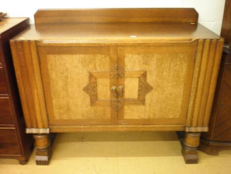 An oak sideboard in the Art Deco style with two panel doors on