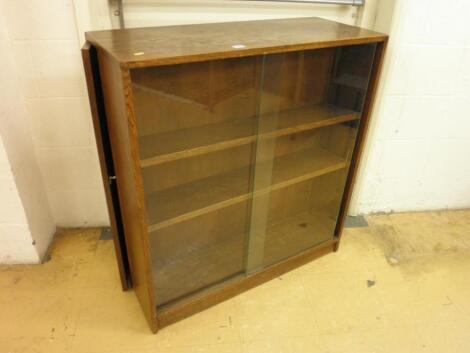 An oak open bookcase with hinged secret compartments to the sides